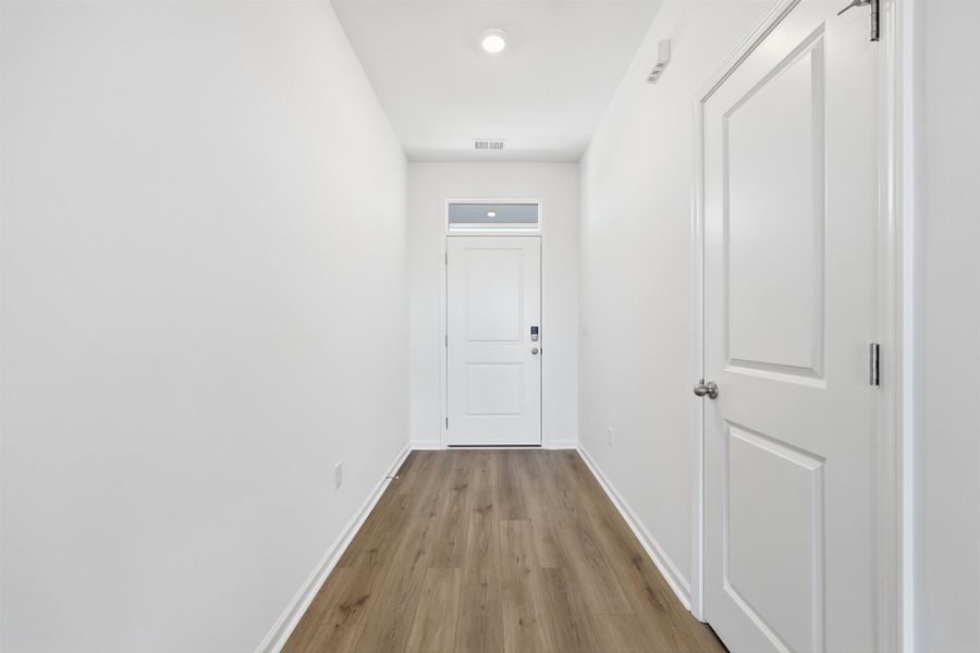 Hall with light wood-style floors and baseboards