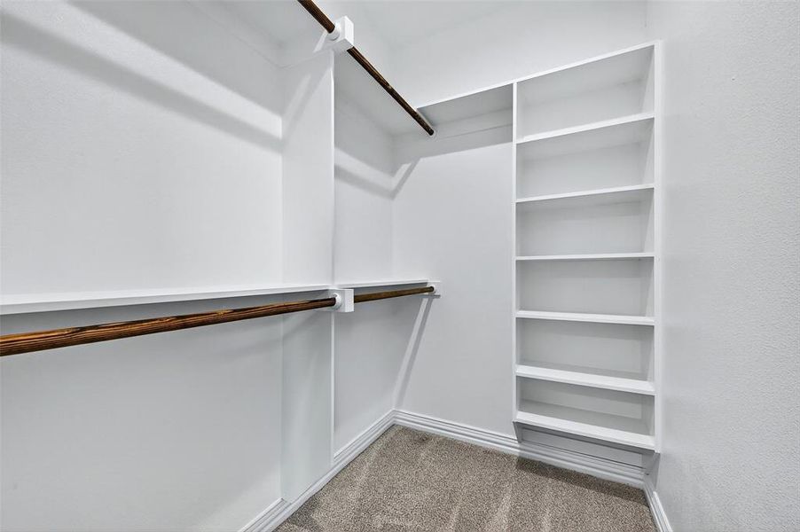 Walk in closet featuring light carpet Walk in closet featuring light carpet