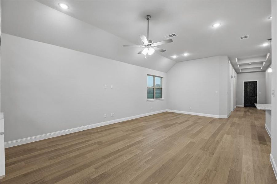 Unfurnished room with vaulted ceiling, light wood finished floors, recessed lighting, and a ceiling fan Unfurnished room with vaulted ceiling, light wood finished floors, recessed lighting, and a ceiling fan