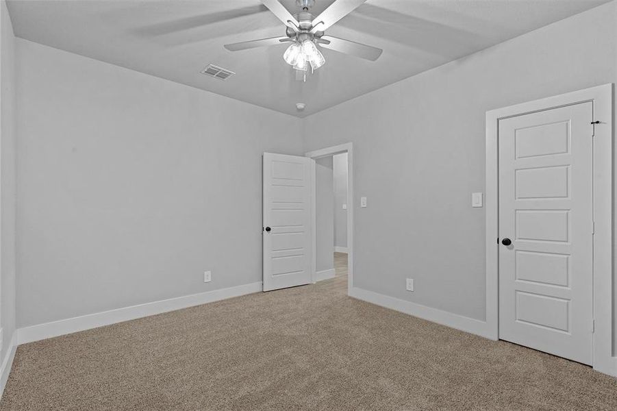 Carpeted spare room with ceiling fan