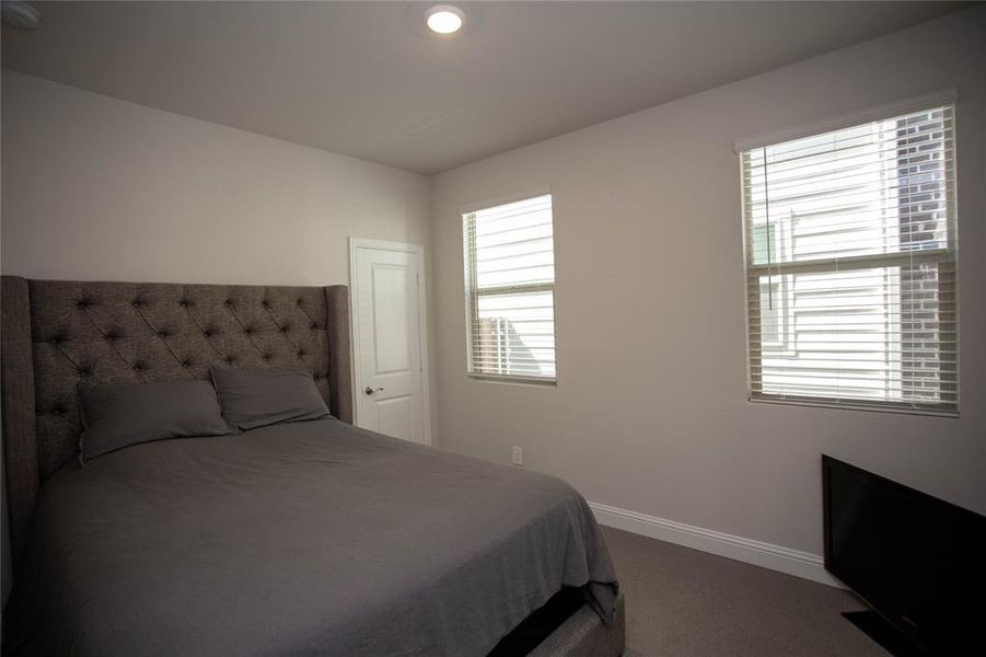 Bedroom featuring carpet and baseboards
