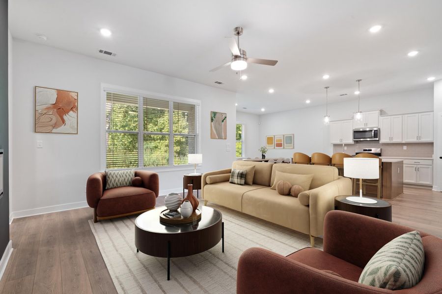 Open-concept living space featuring wood-finish flooring, recessed lighting, and a ceiling fan