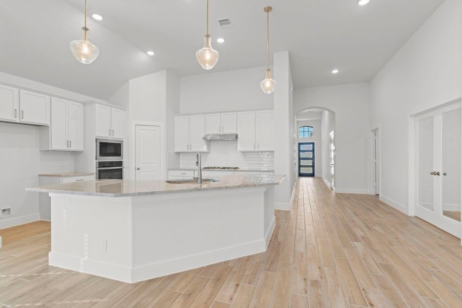 Massive eat in working station island with beautiful granite countertops, gorgeous pendant lighting.  Stunning view!