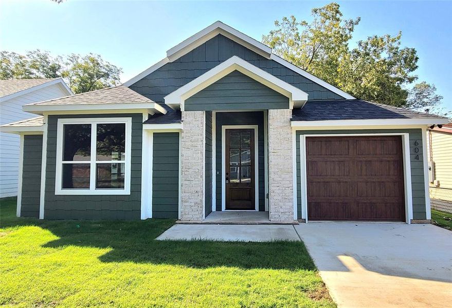 View of front of home featuring a garage and a front lawn