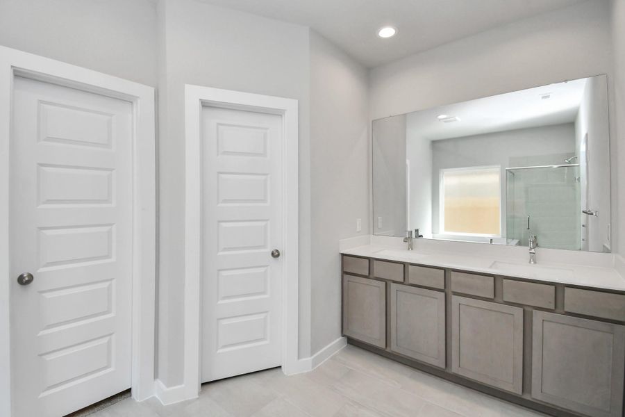 Elevate your daily routine at the elegant vanity, now equipped with double sinks, light countertops, modern hardware, and beautiful recessed lights. Sample photo of completed home with similar floor plan. Actual colors and selections may vary. Elevate your daily routine at the elegant vanity, now equipped with double sinks, light countertops, modern hardware, and beautiful recessed lights. Sample photo of completed home with similar floor plan. Actual colors and selections may vary.