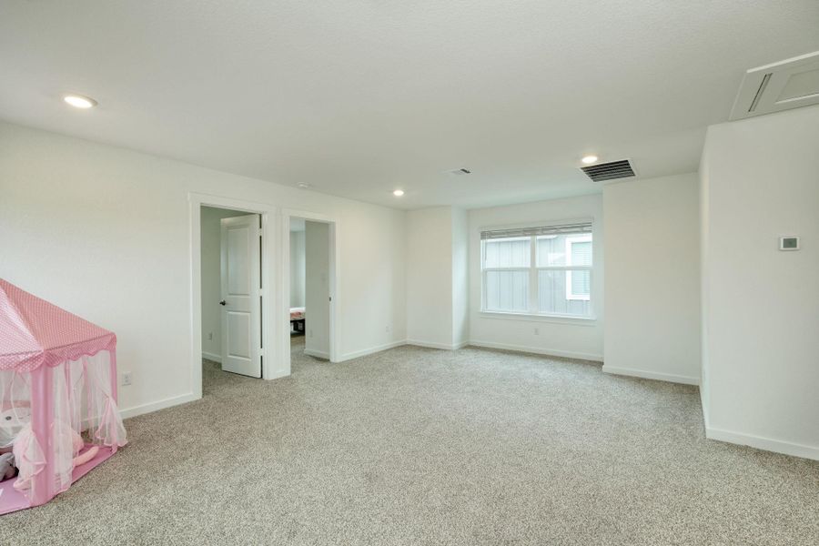 Carpeted empty room featuring baseboards, visible vents, and recessed lighting