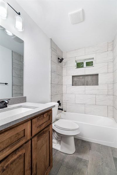 Bathroom with shower / bathtub combination, vanity, and dark wood-style flooring Bathroom with shower / bathtub combination, vanity, and dark wood-style flooring