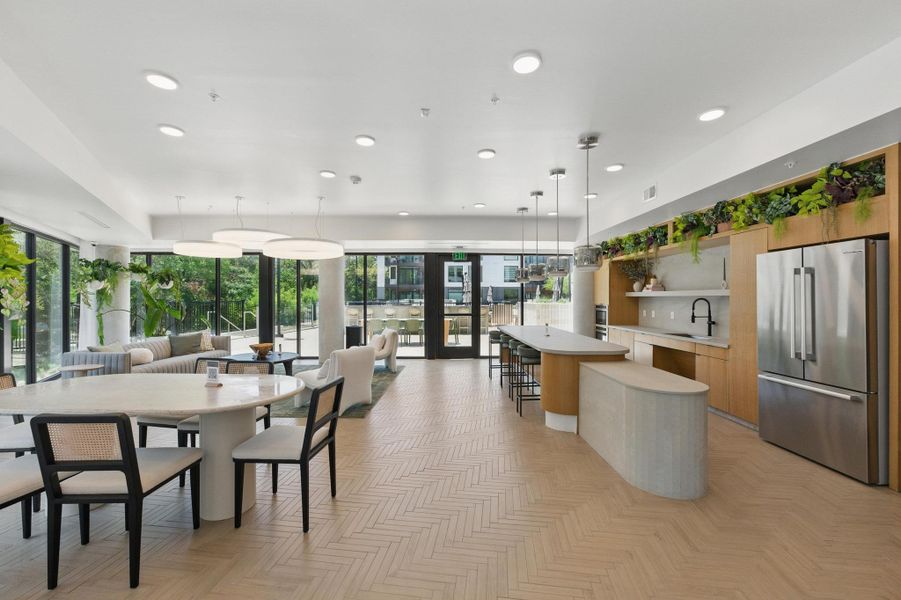 Herringbone wood floors define this open concept living space, merging kitchen, dining, and lounge areas seamlessly.