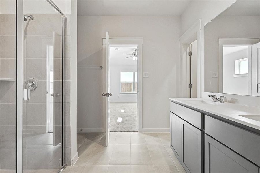 Bathroom with ceiling fan, vanity, walk in shower, and tile patterned floors