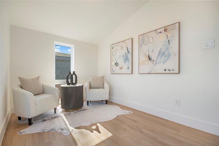 Living area with wood finished floors and vaulted ceiling Living area with wood finished floors and vaulted ceiling