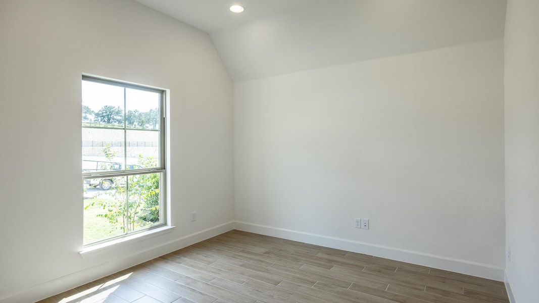 Spare room with vaulted ceiling, wood tiled floors, and recessed lighting