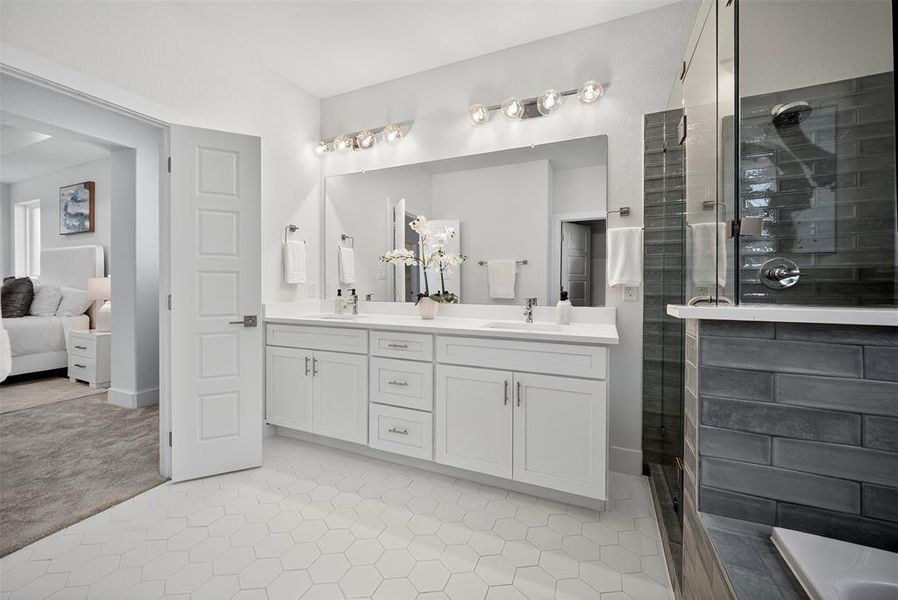 Bathroom featuring double vanity, a shower stall, ensuite bathroom, and light tile patterned floors Bathroom featuring double vanity, a shower stall, ensuite bathroom, and light tile patterned floors