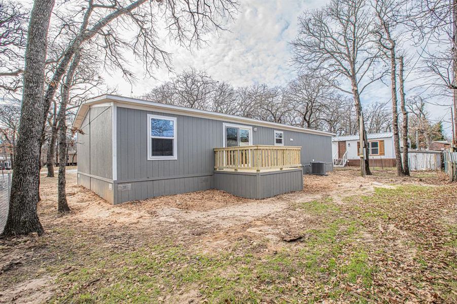 Back of property featuring a wooden deck and central AC unit Back of property featuring a wooden deck and central AC unit