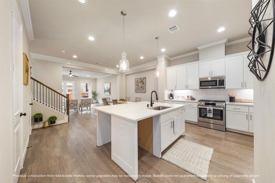 Culinary Excellence: Centered around a generous kitchen island, this modern chef's paradise boasts the latest in sleek stainless steel appliances from LG, marrying function with sophistication.