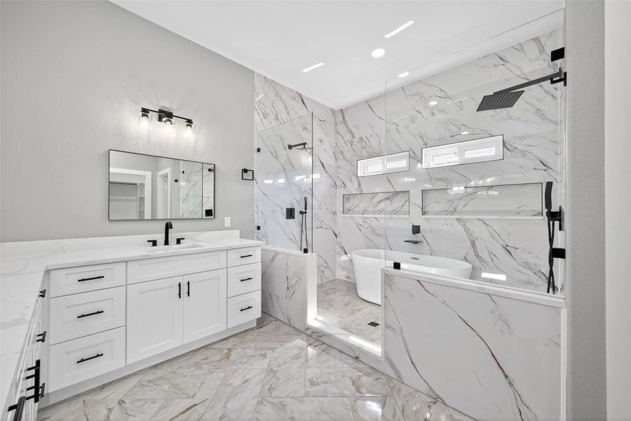 Luxurious primary bath with dual vanities, soaking tub, and spacious shower. Luxurious primary bath with dual vanities, soaking tub, and spacious shower.