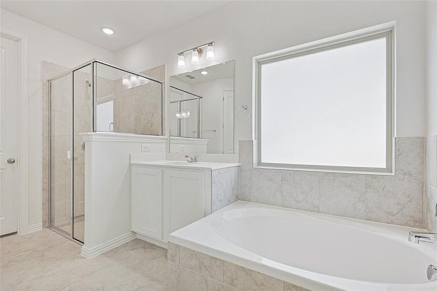Full bathroom with a stall shower, vanity, and a bath