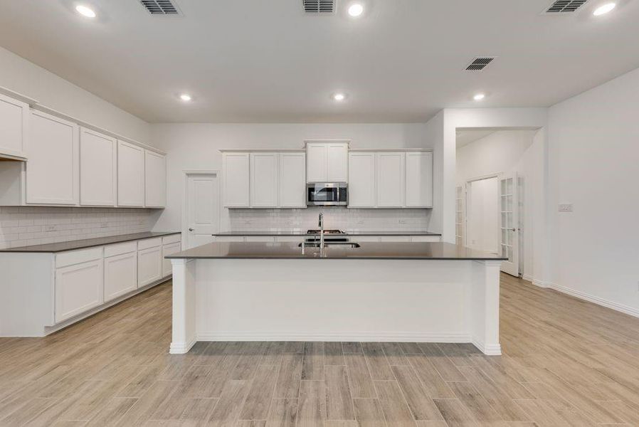 Kitchen featuring light hardwood / wood-style floors and white cabinetry