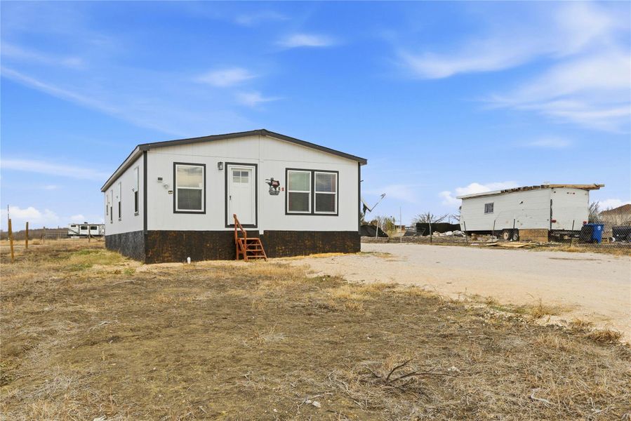 A modest modular home stands ready for personalization on a spacious, open lot.