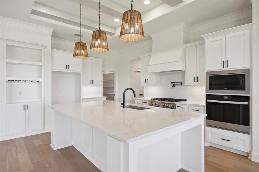 Kitchen featuring a center island with sink, white cabinets, and appliances with stainless steel finishes