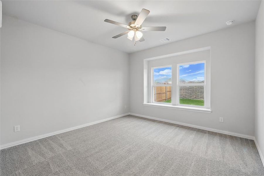 Empty room with carpet, a ceiling fan, and a smoke detector