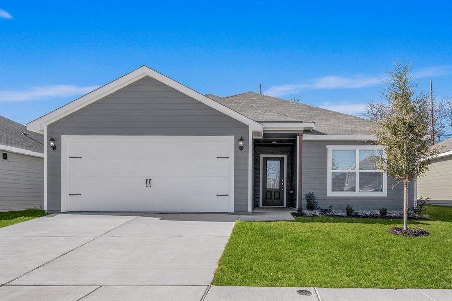 Single story home featuring a garage and a front yard