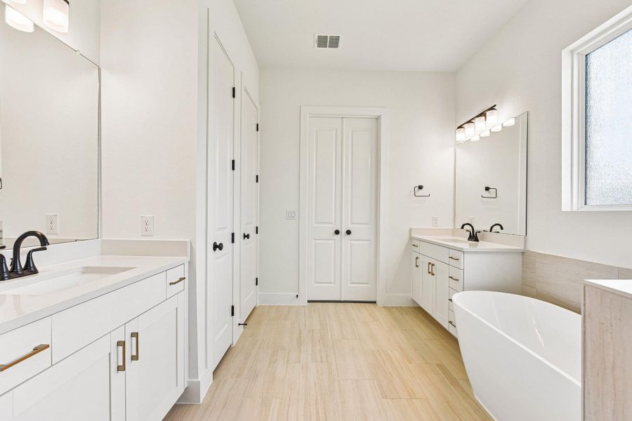 Dual vanities and a freestanding tub create a primary bathroom sanctuary. Dual vanities and a freestanding tub create a primary bathroom sanctuary.