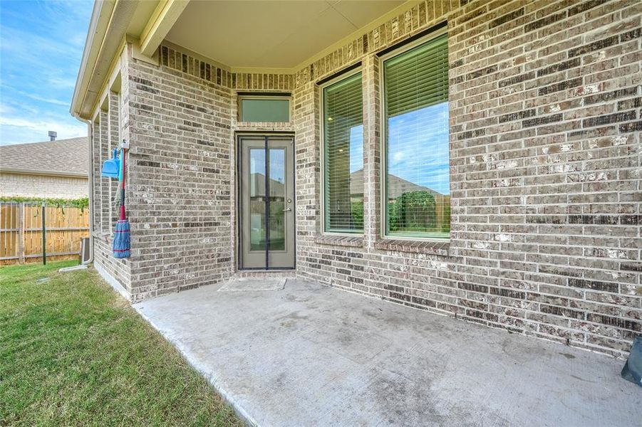 Doorway to property with brick siding and a patio Doorway to property with brick siding and a patio