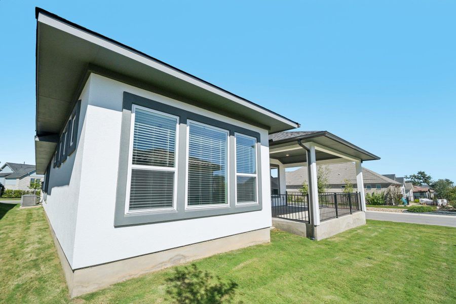 View of property exterior featuring a yard and a central air condition unit