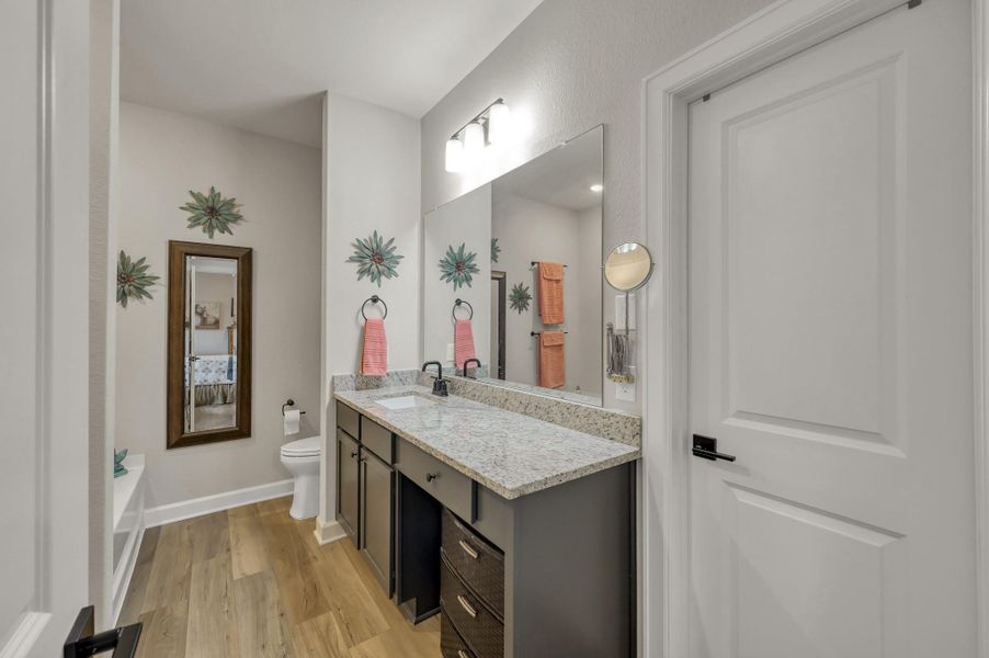 Well-appointed primary bath featuring granite countertops, generous vanity space, modern fixtures, and a spacious layout designed for everyday comfort and convenience. Well-appointed primary bath featuring granite countertops, generous vanity space, modern fixtures, and a spacious layout designed for everyday comfort and convenience.