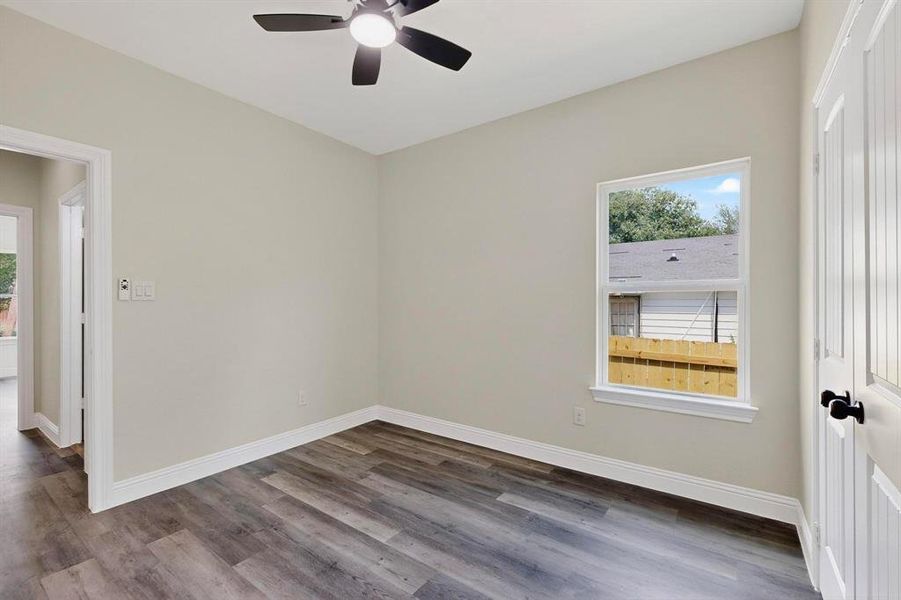 Spare room featuring plenty of natural light, dark wood finished floors, and a ceiling fan Spare room featuring plenty of natural light, dark wood finished floors, and a ceiling fan