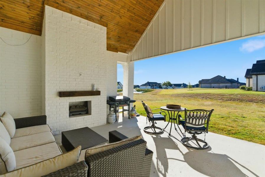 View of patio / terrace featuring a grill, a residential view, and an outdoor living space with a fireplace