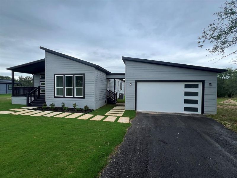View of front of home with a front yard and driveway