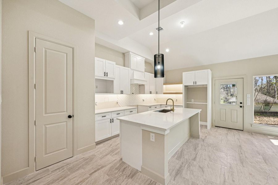 This beautifully designed kitchen offers an under-mount sink, soft-close white cabinetry with under-cabinet lighting.