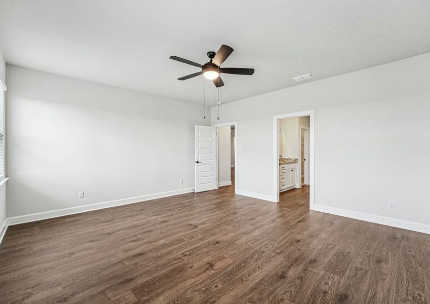 primary bedroom featuring a ceiling fan and wood-look vinyl flooring open to the dining area. primary bedroom featuring a ceiling fan and wood-look vinyl flooring open to the dining area.