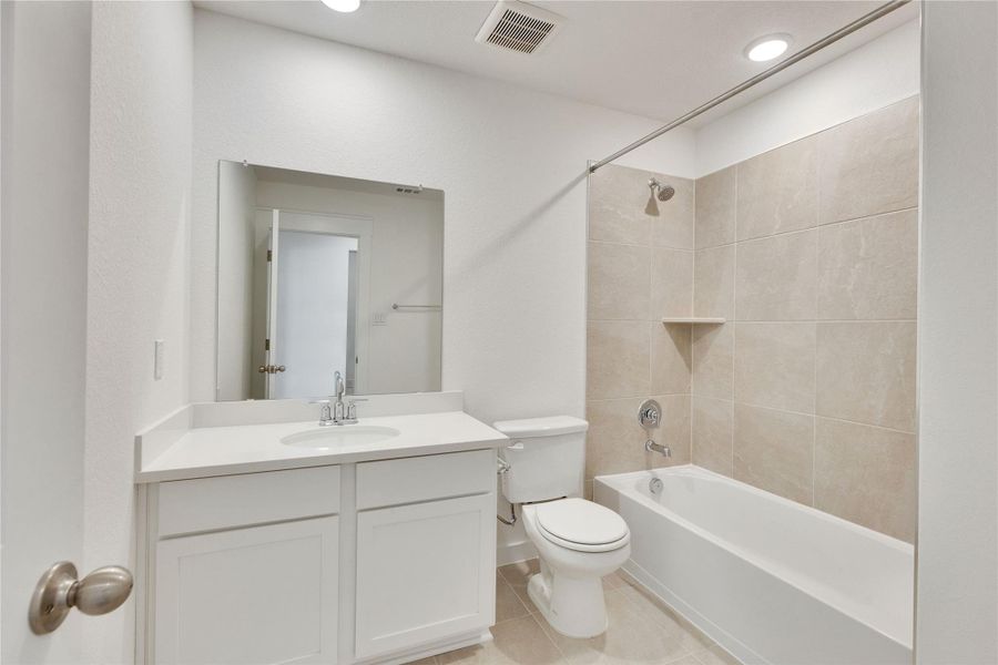 Bathroom featuring shower / washtub combination, light tile patterned floors, vanity, and recessed lighting Bathroom featuring shower / washtub combination, light tile patterned floors, vanity, and recessed lighting