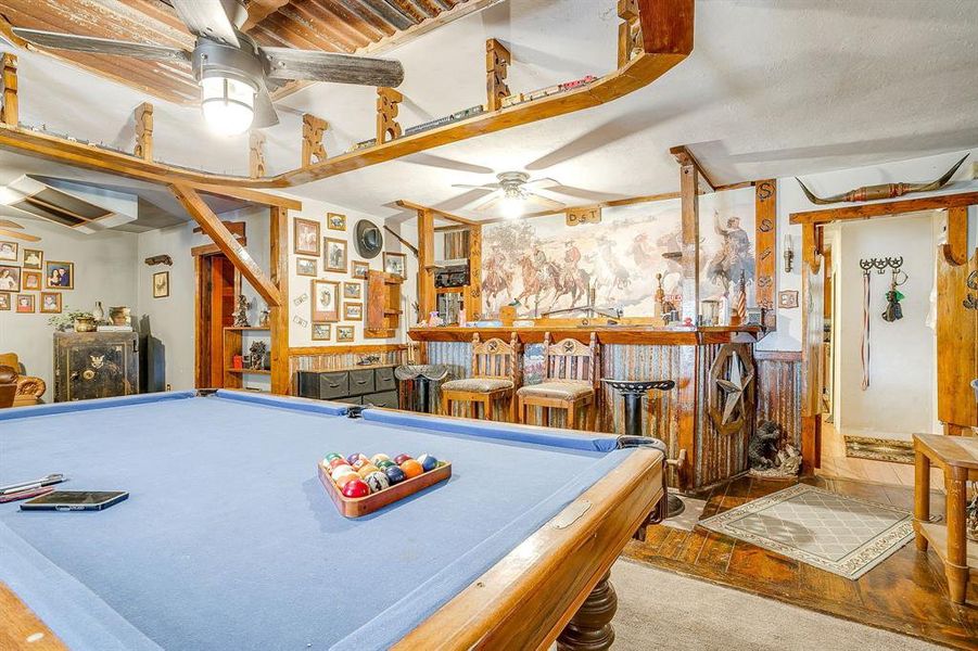 Playroom with a dry bar, billiards, a ceiling fan, a wainscoted wall, and wood finished floors Playroom with a dry bar, billiards, a ceiling fan, a wainscoted wall, and wood finished floors