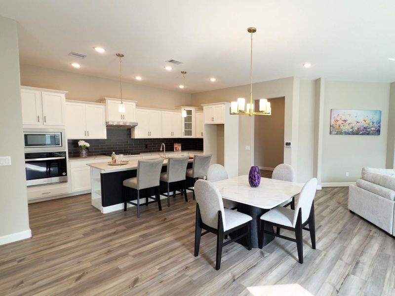 Bright and inviting, the dining area offers the perfect setting for intimate dinners or lively gatherings, seamlessly connected to the kitchen and living spaces for effortless entertaining. Image depicts home as-is.