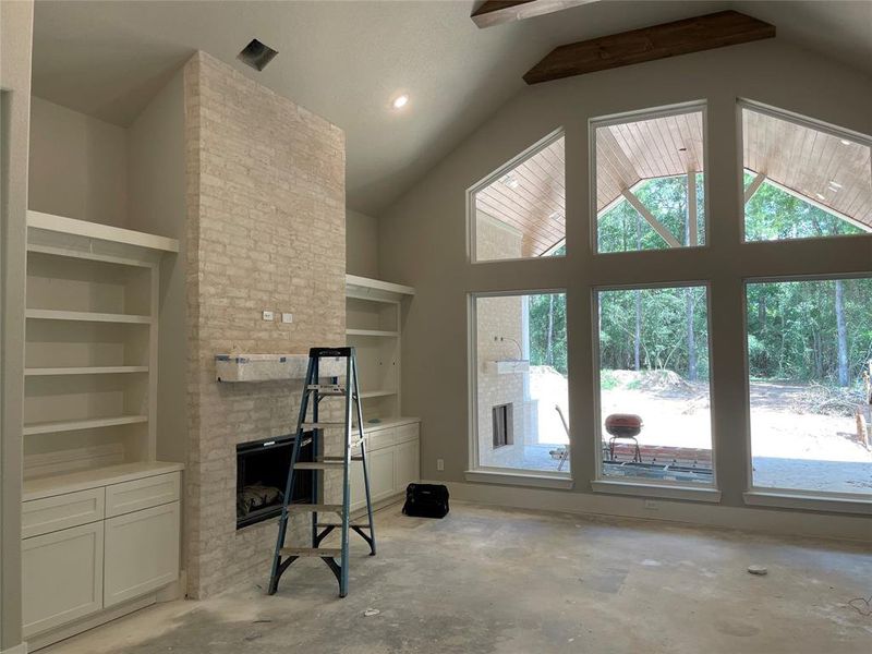 Custom built ins, beams and a wall of windows overlooking outdoor living area and private back yard!