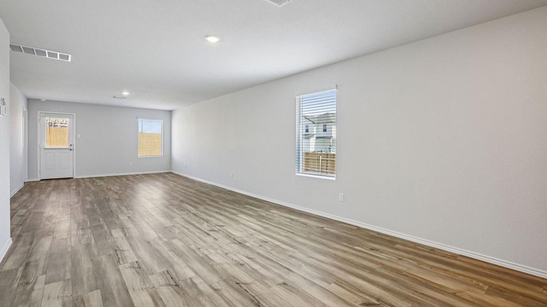Spare room featuring wood finished floors, plenty of natural light, and recessed lighting