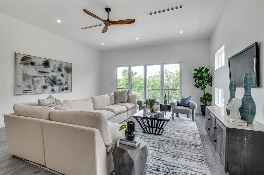 Living room with ceiling fan and light wood-type flooring