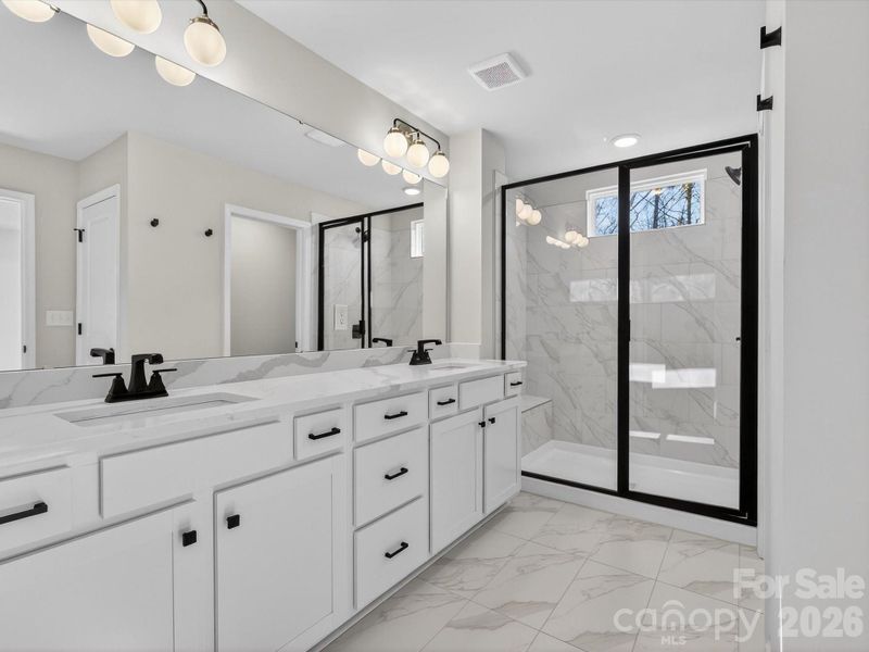 Enjoy spending time in the primary bathroom with designer features large, tiled shower with bench, large Dual vanity with quartz countertops, separate toilet and large walk-in closet