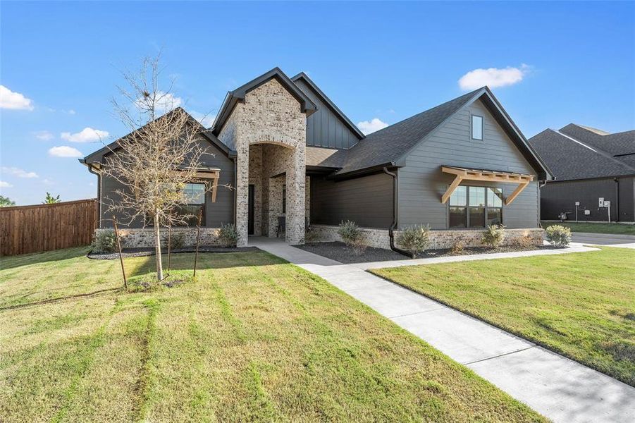 View of front of home with stone siding and roof with shingles View of front of home with stone siding and roof with shingles