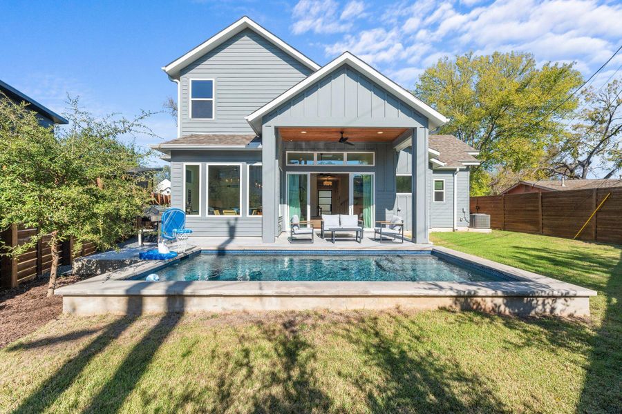 Back of house with a ceiling fan, board and batten siding, a fenced backyard, and a patio