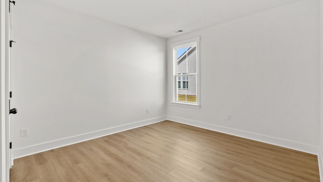 Spacious secondary bedroom with durable LVP flooring throughout the home.