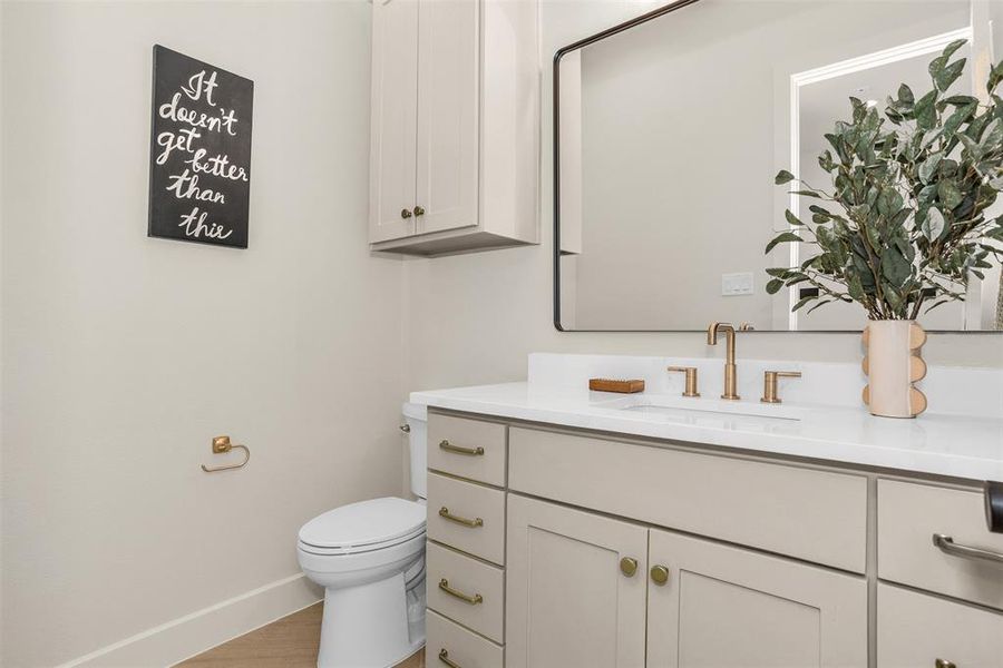 Half bath featuring vanity and light wood-style floors Half bath featuring vanity and light wood-style floors