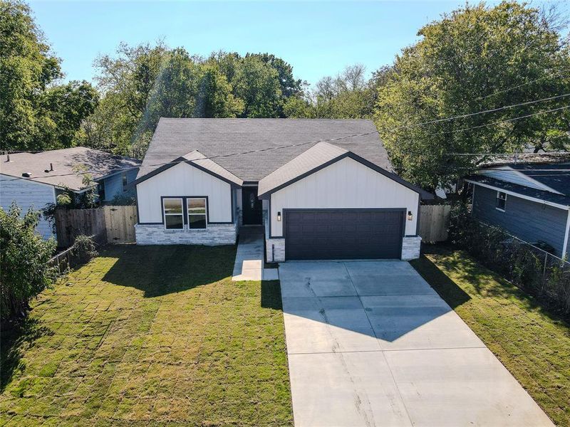 View of front of property featuring a front yard and a garage