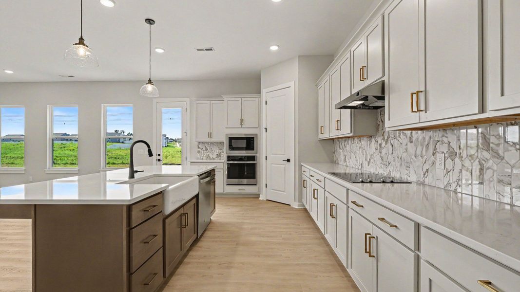 Huge kitchen with quartz countertops and accent backsplash, with a corner pantry and tons of workspace