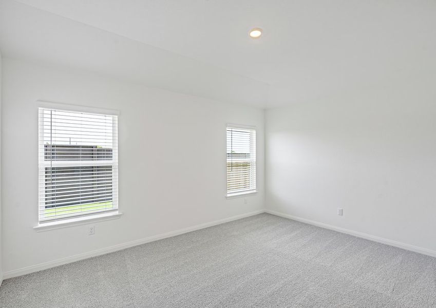 Master bedroom with two windows and lush carpet