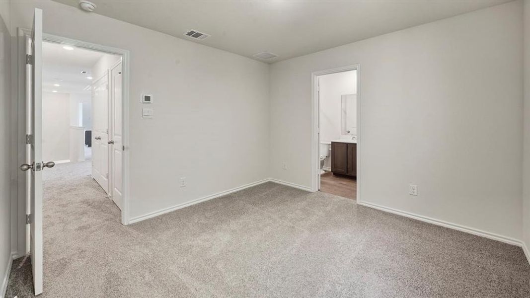 Empty room with light colored carpet and baseboards