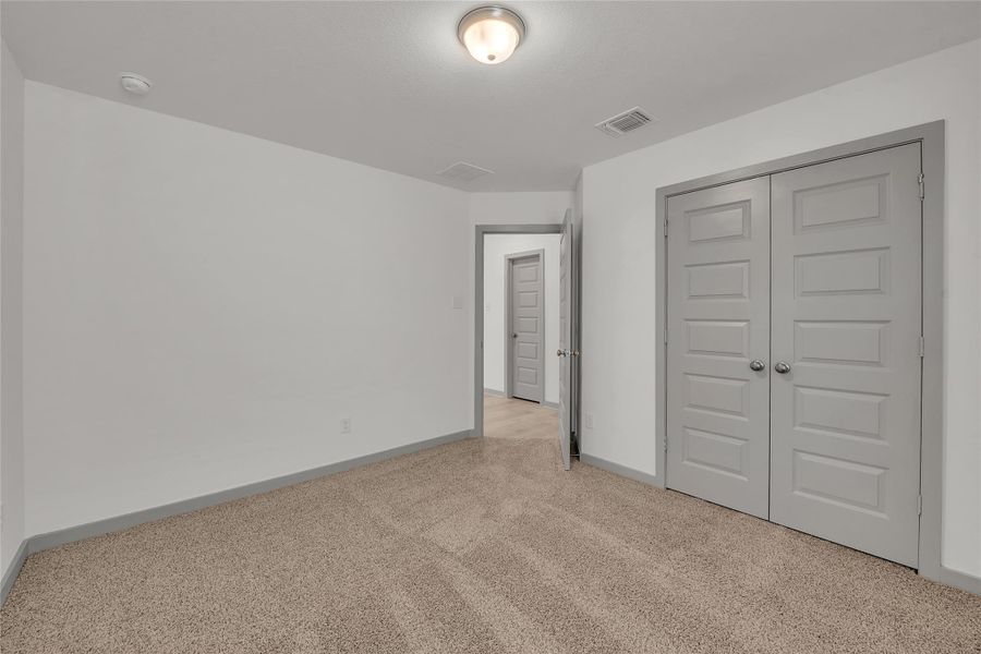 Unfurnished bedroom featuring light colored carpet and a closet